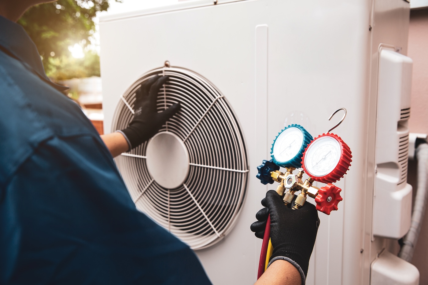 Heat and Air Conditioning, HVAC system service technician using measuring manifold gauge checking refrigerant and filling industrial air conditioner after duct cleaning maintenance outdoor compressor.