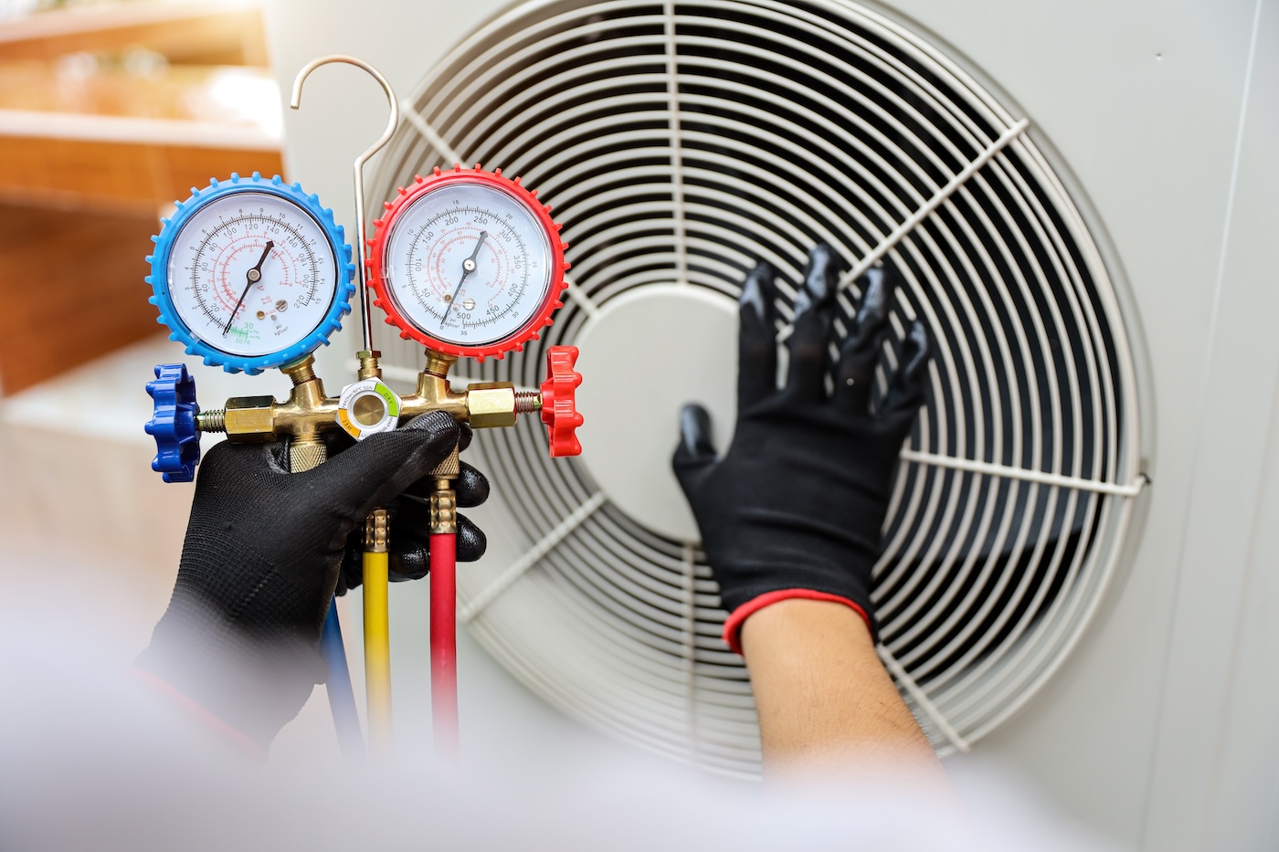 Technician using manifold gauge measuring tool checking refrigerant pump filling home air conditioner and maintenance heat fix repair and clean outdoor air compressor unit.