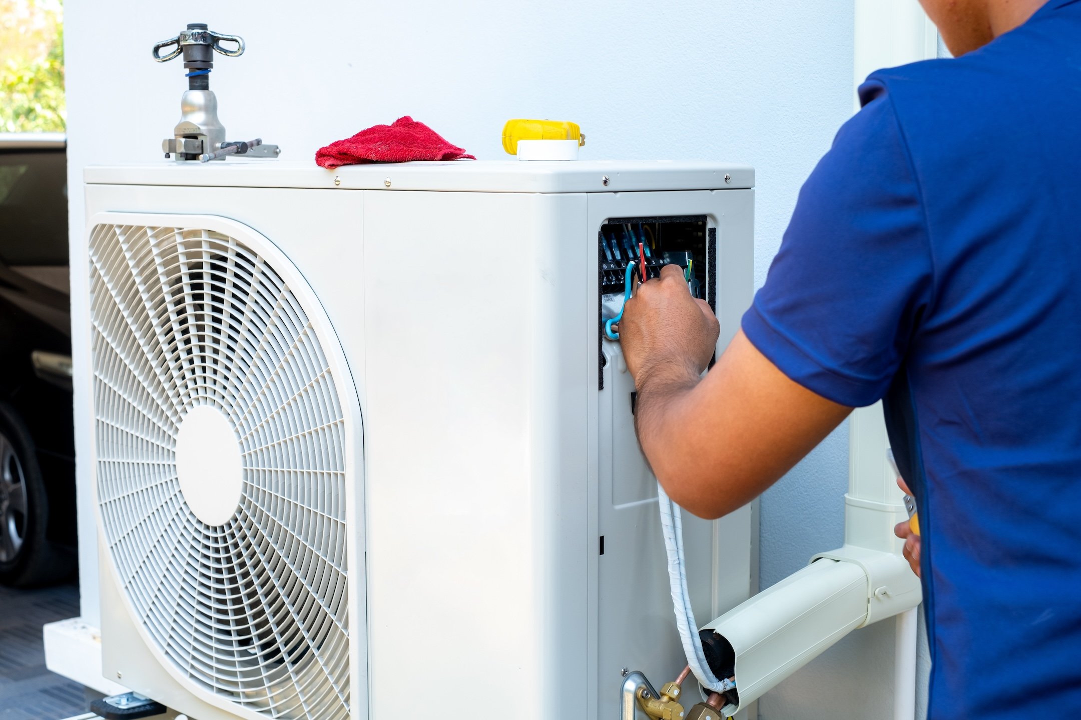 Male technician installing outdoor unit of air conditioner to cool the household in the summer. air compressor, electronic, hot summer, high temperature, Tropical countries